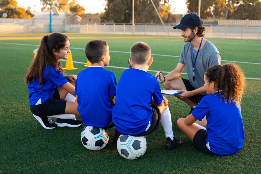 A football trainer teaching kids